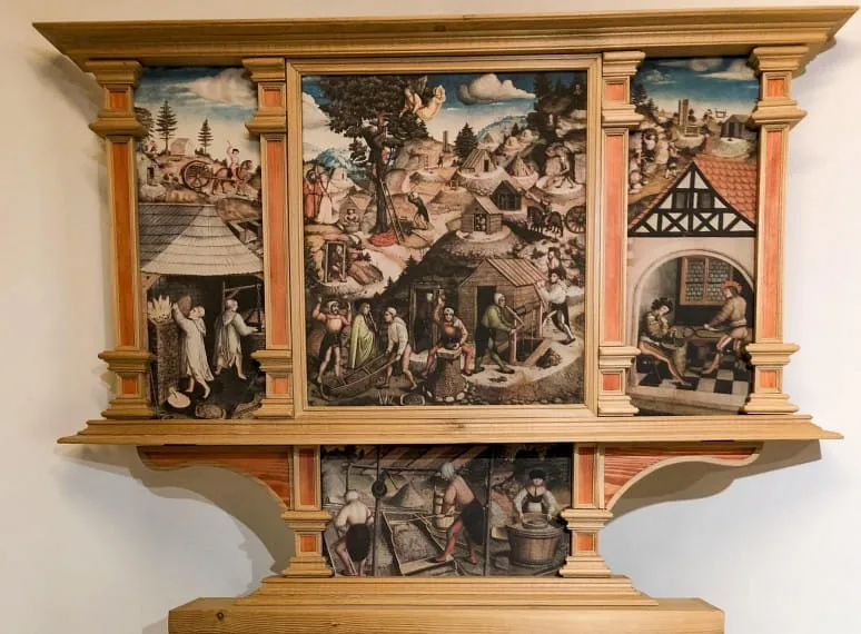 Historischer Altaraufsatz mit detaillierten Szenen aus dem Leben und Arbeiten der Bergleute, in einem kunstvoll gestalteten Holzrahmen. 