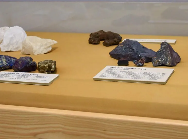 Ausstellungsvitrine mit verschiedenen Mineralien und dazugehörigen Beschreibungen auf Kärtchen. 