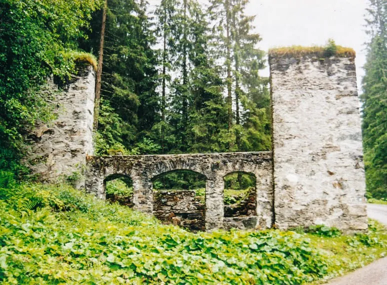 Pochwerk-Ruine im Wald mit Bögen und überwuchertem Dach. 